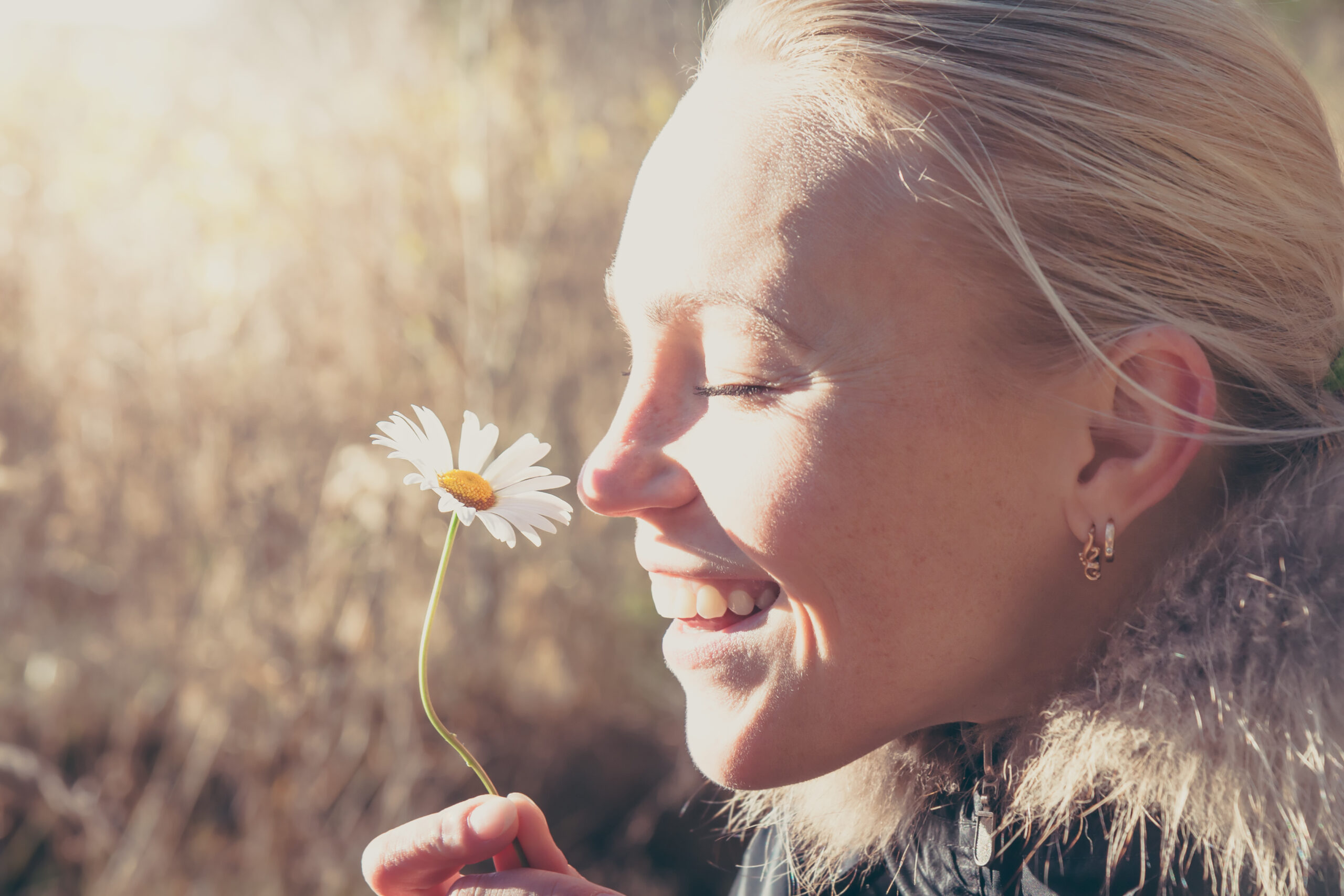 Happy,Woman,Smelling,Daisy,Flower,Hanging,It,In,Hands